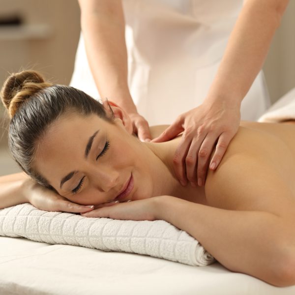 Portrait of a relaxed lady receiving a massage in a spa interior